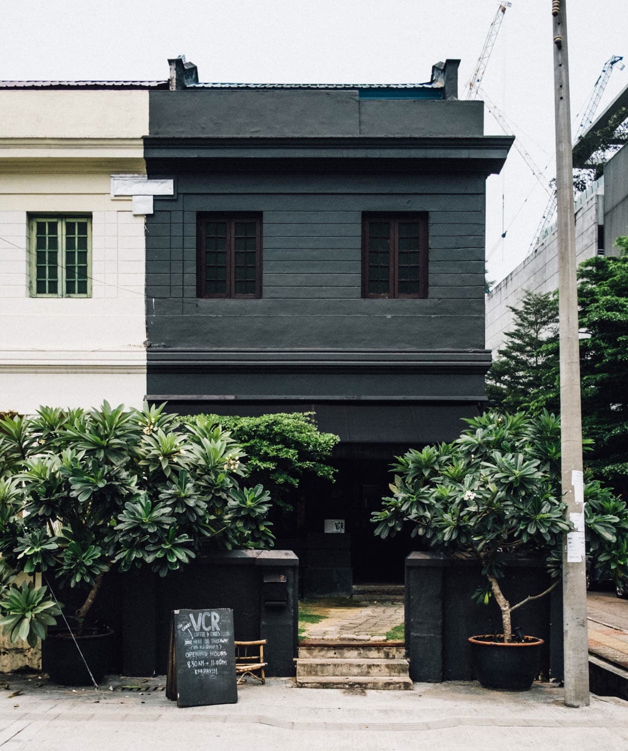 A black and white townhouse surrounded by greenery
