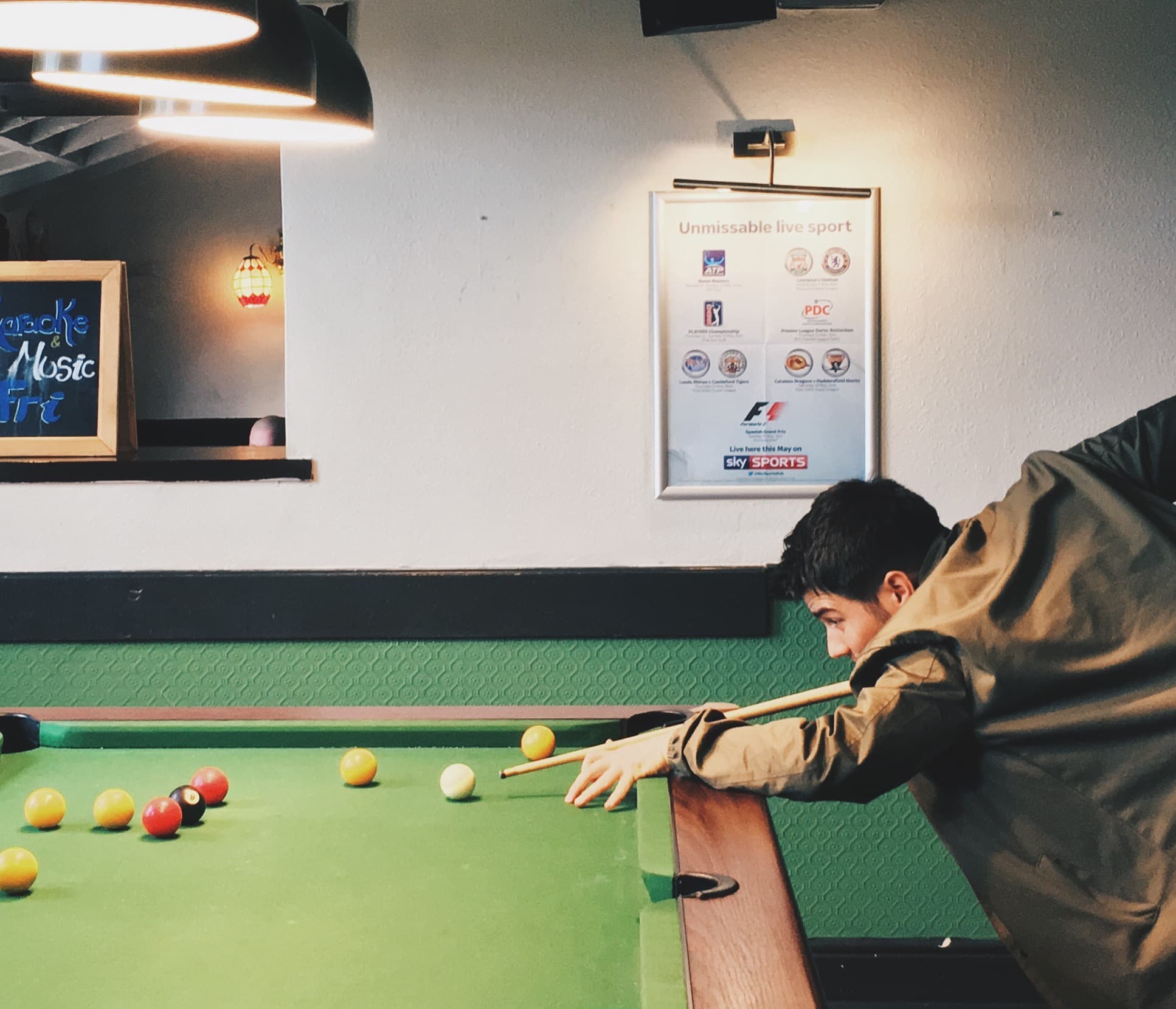 A person lining up a shot on a pool table