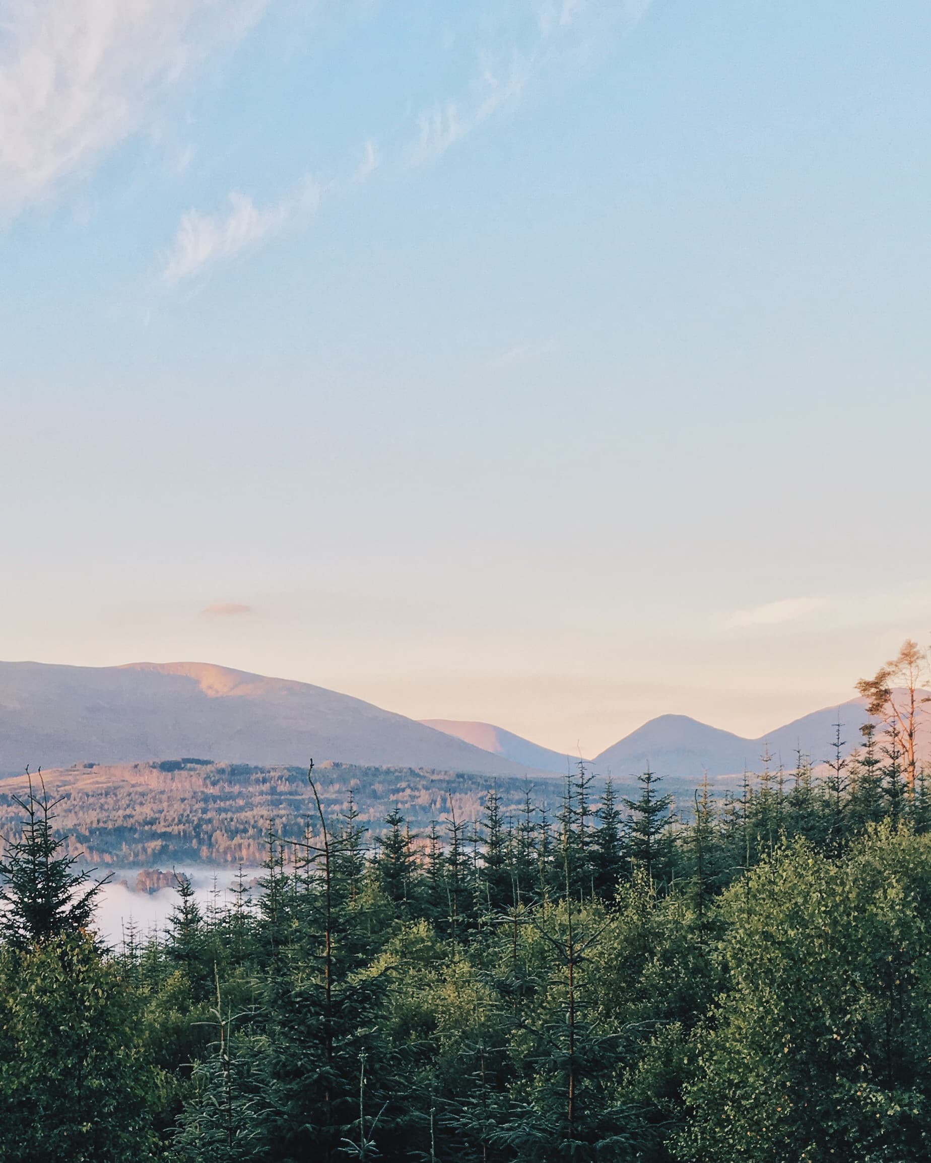 A town and mountains seen across a lake at sunset