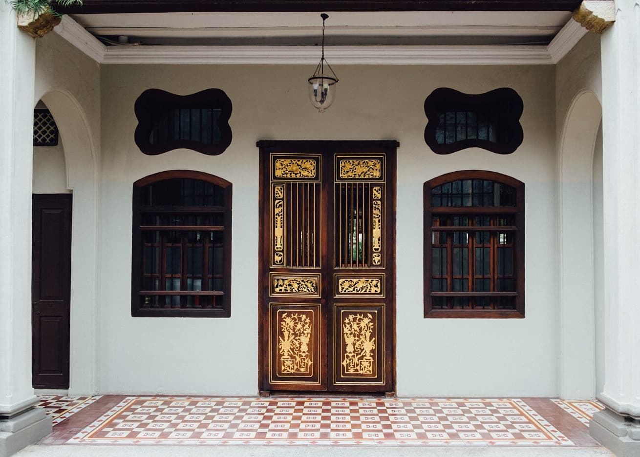 An ornate gold doorway beneath a covered terrace