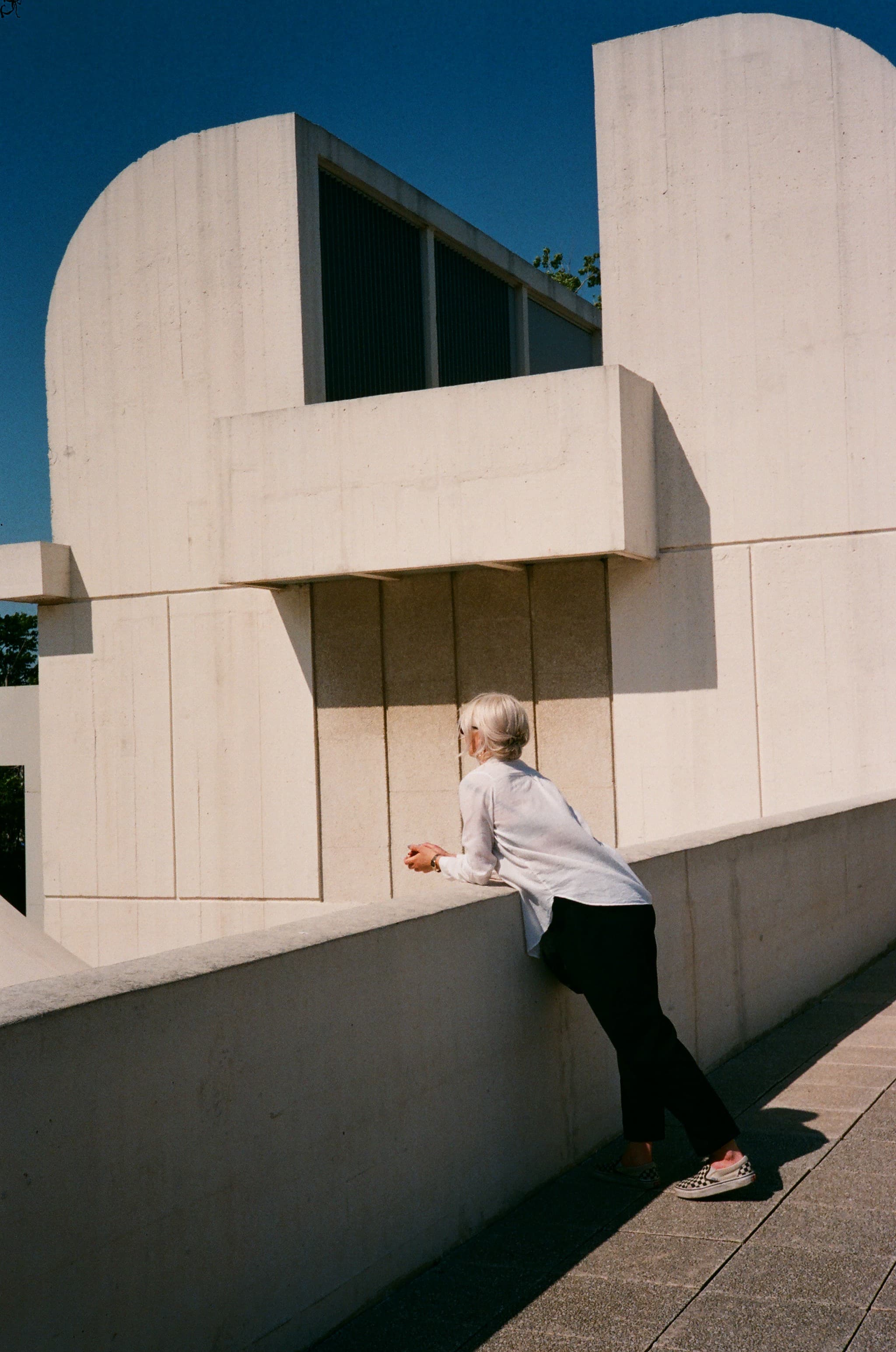 A person beneath the curved facade of a modern building