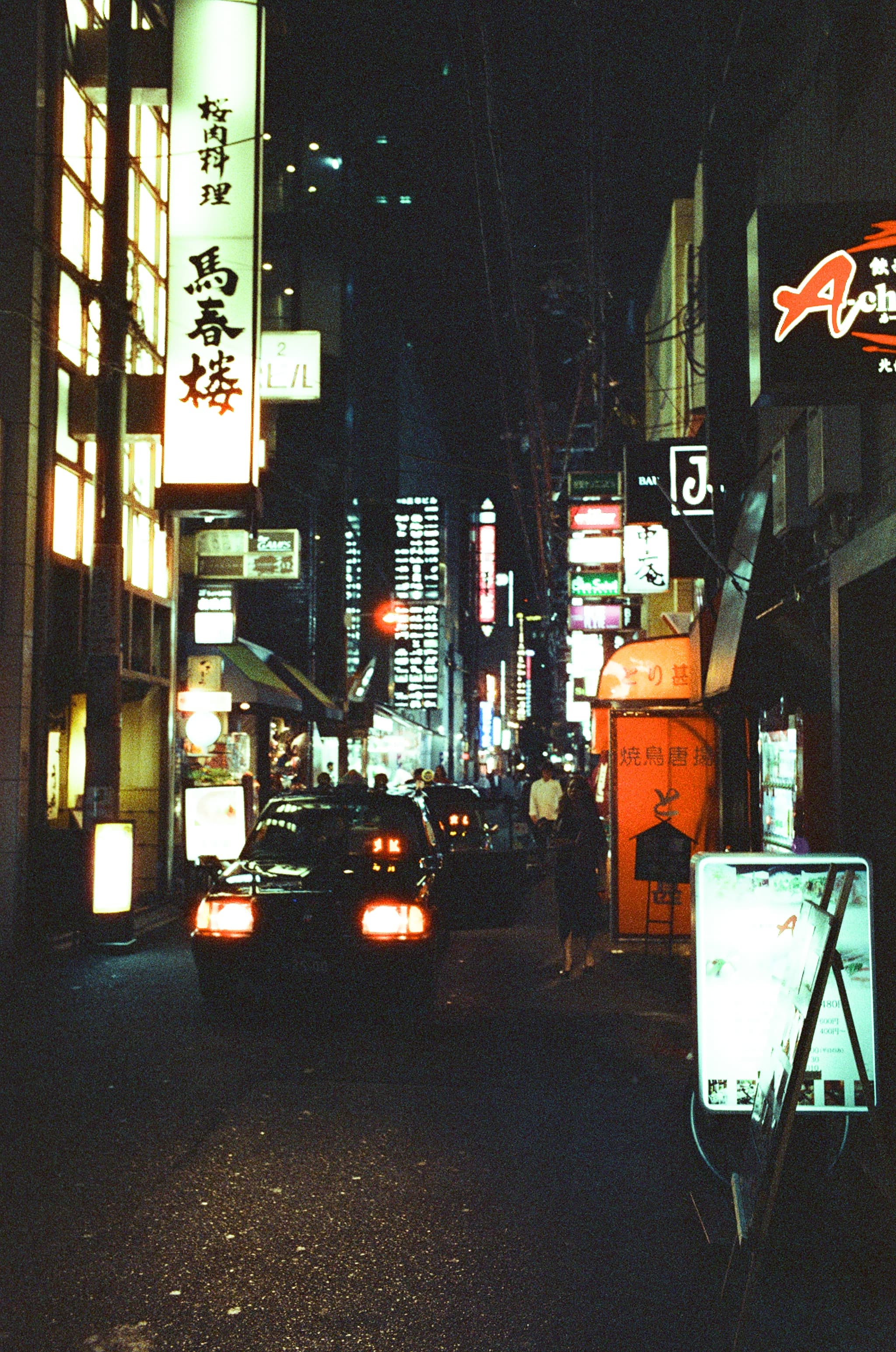 Illuminated signs along a Japanese street at night