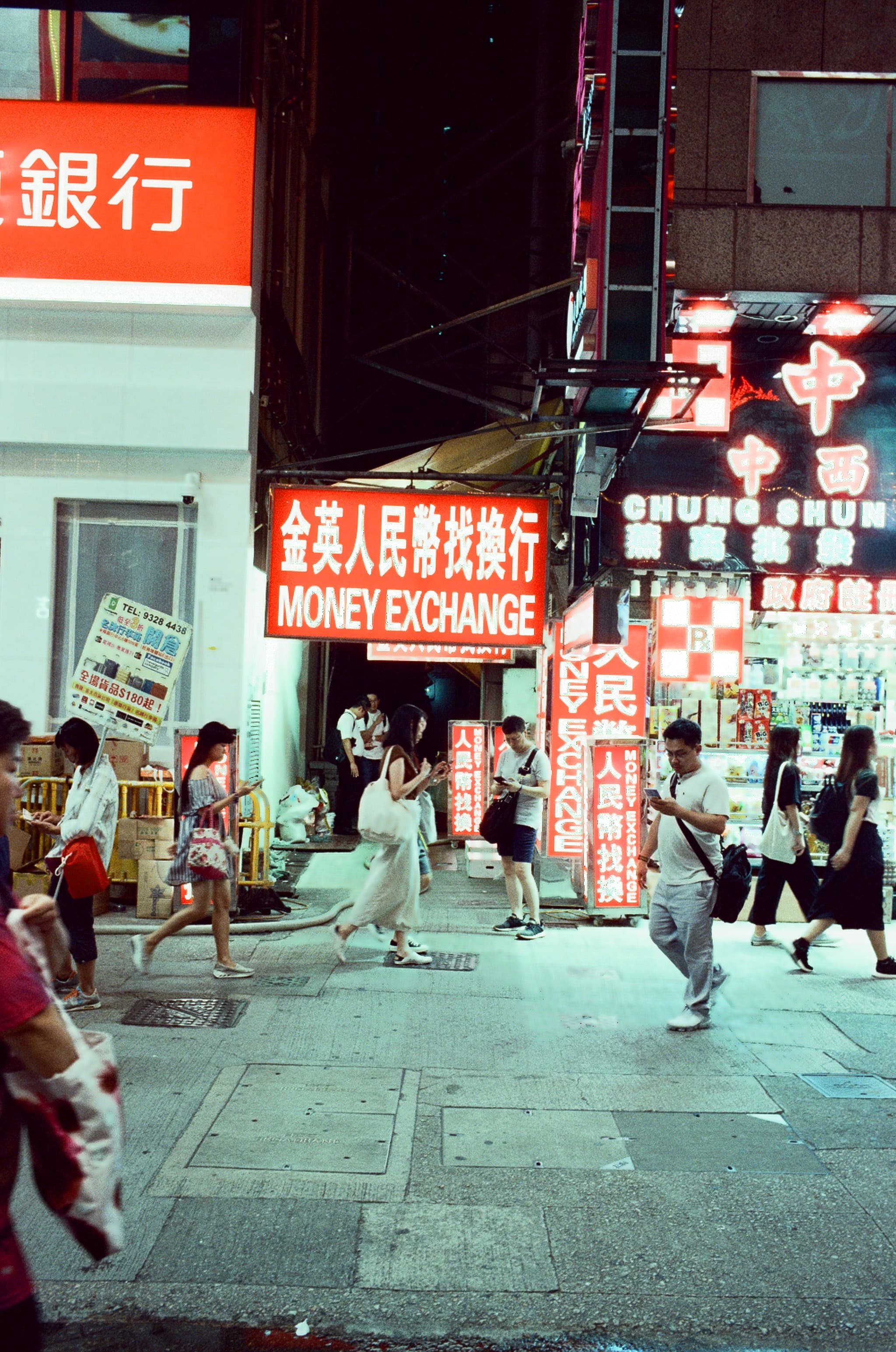 Neon signs above a busy Hong Kong street