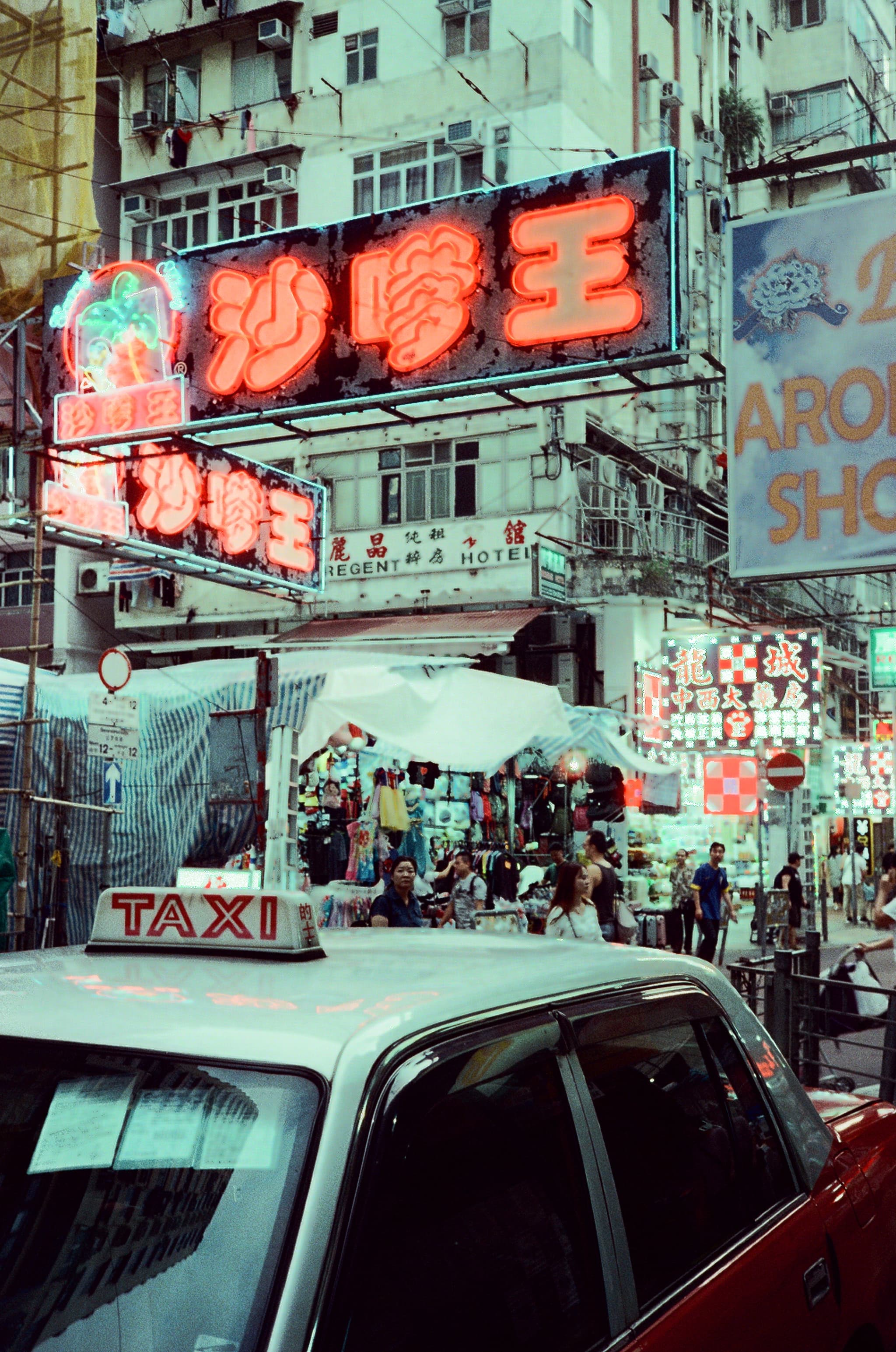A red taxi beneath illuminated street signs