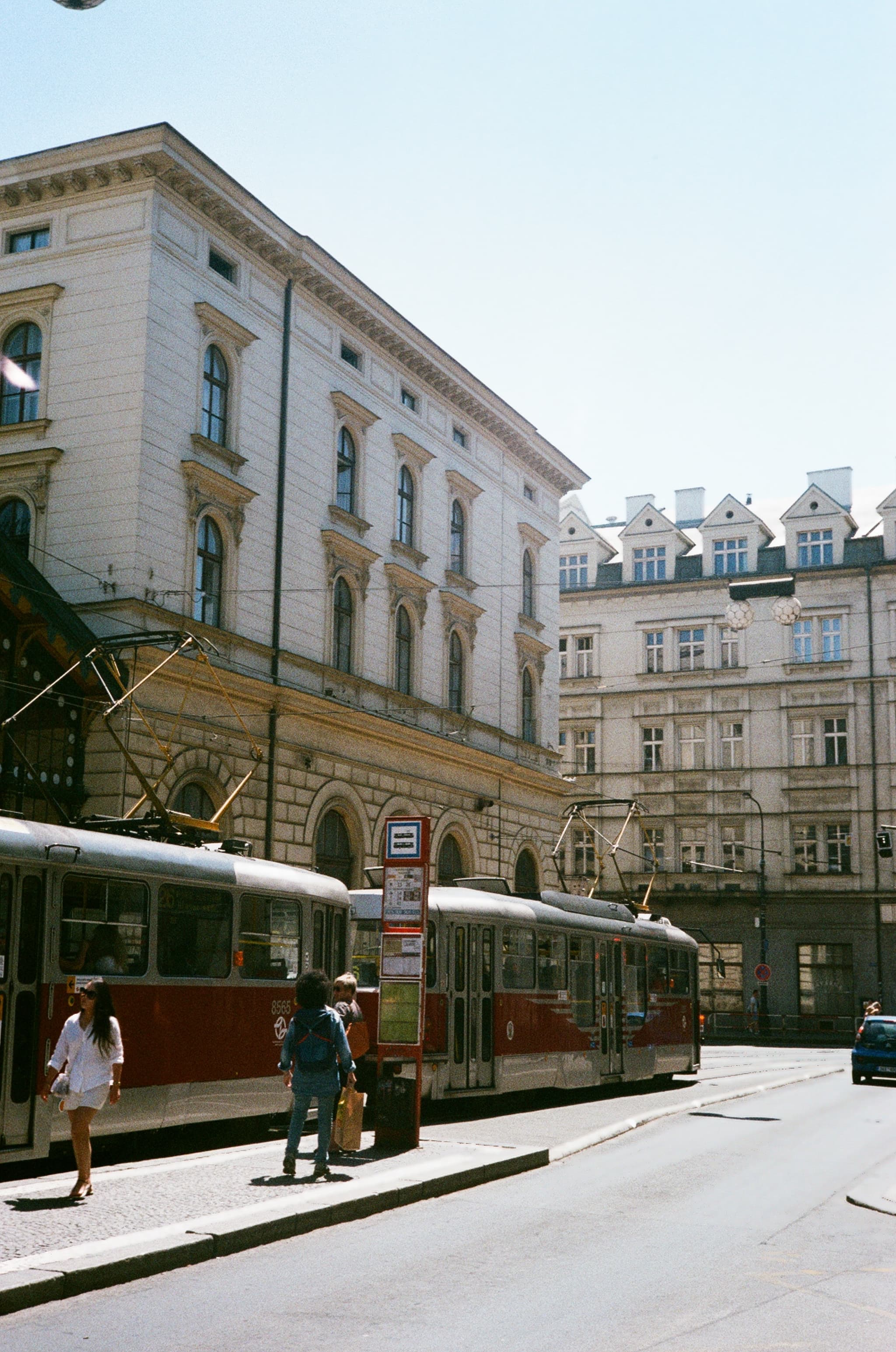 A tram passing through a sunlit city street