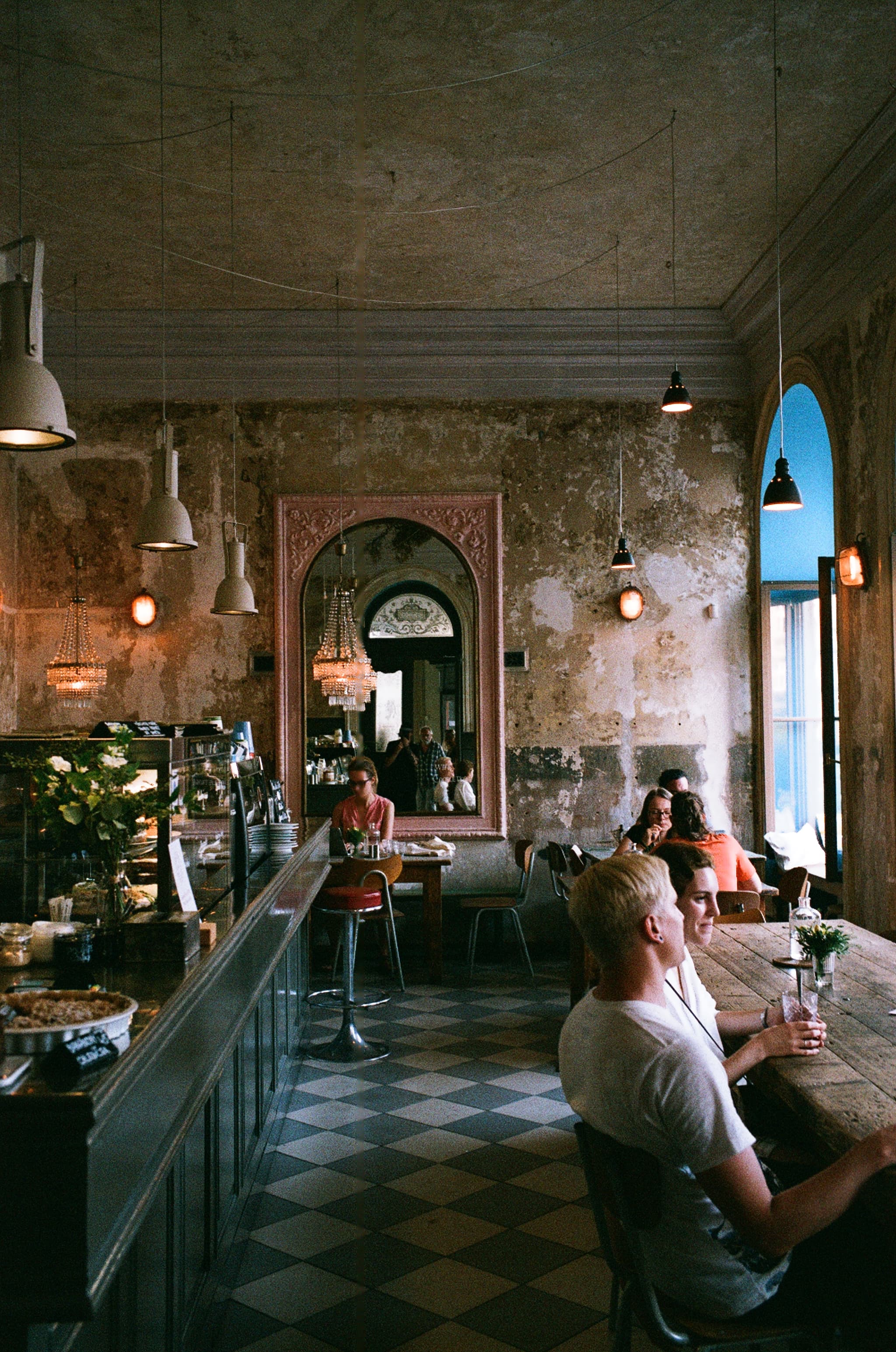A crowded bar reflected in a wall mirror