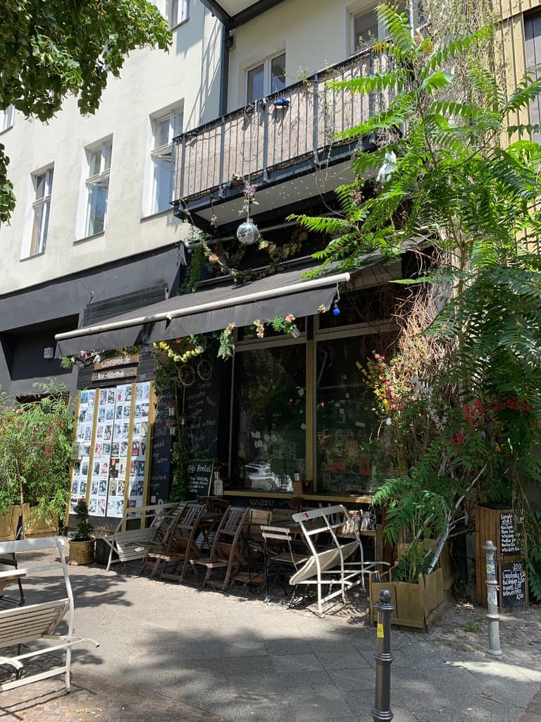 Tables outside a leafy neighbourhood café