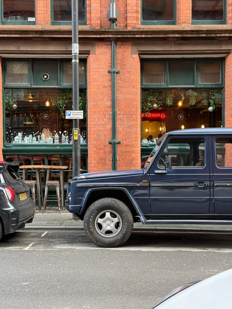 A dark four-wheel drive vehicle parked on a city street