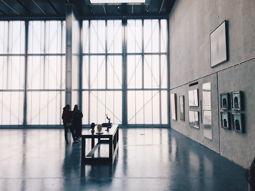 Visitors silhouetted inside a large contemporary gallery
