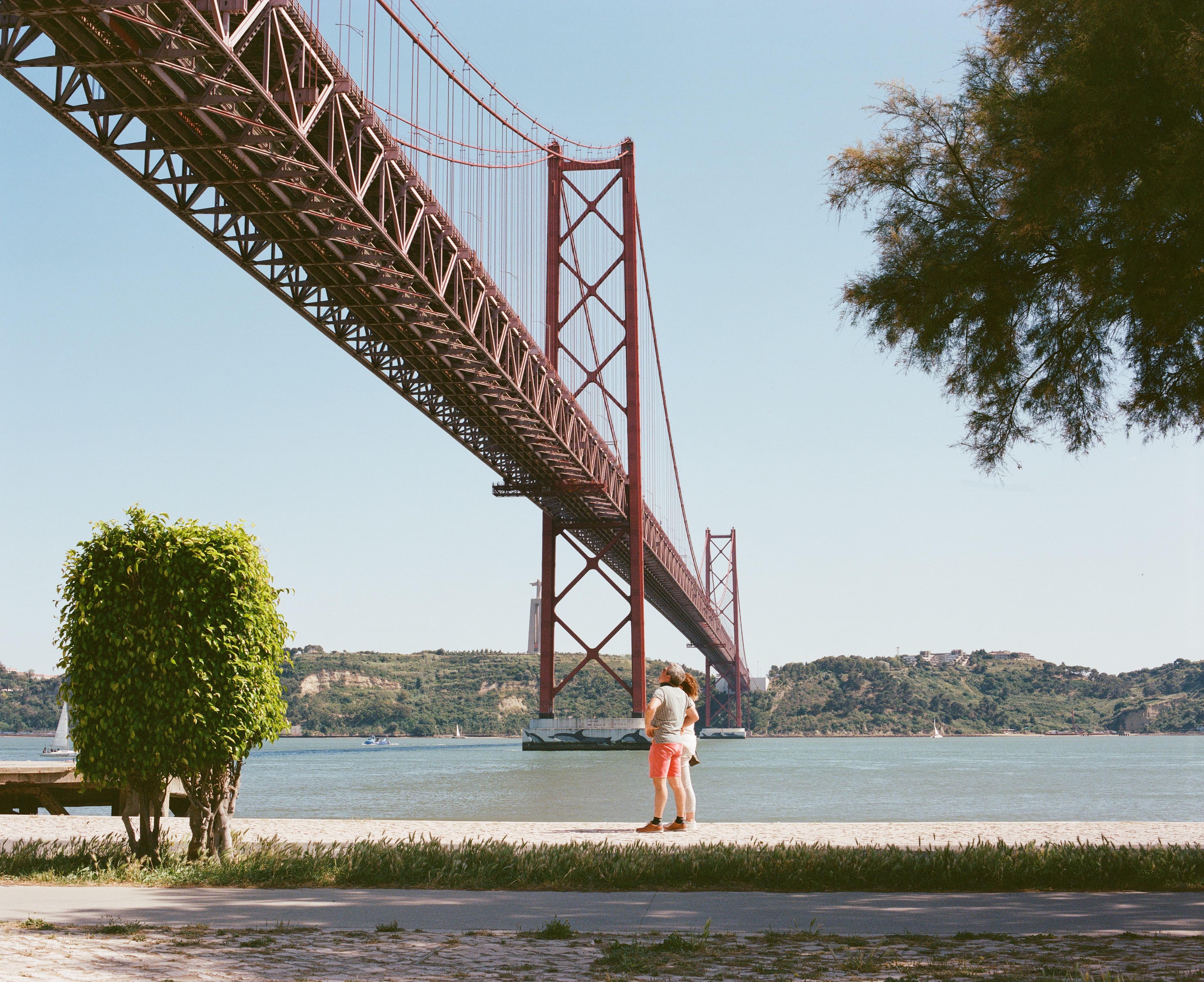 A person beneath the red suspension bridge in Lisbon