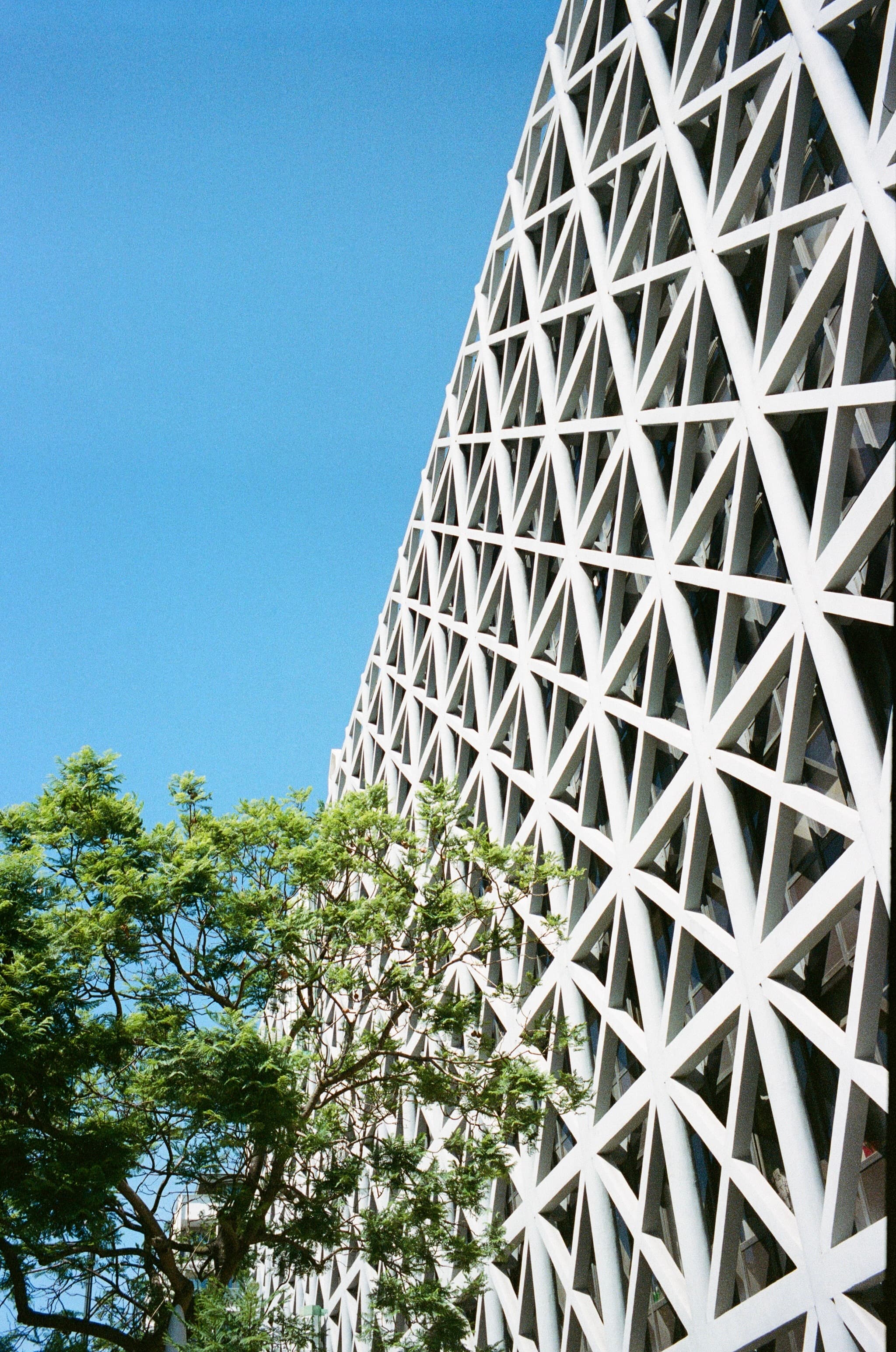 A geometric tower framed against blue sky